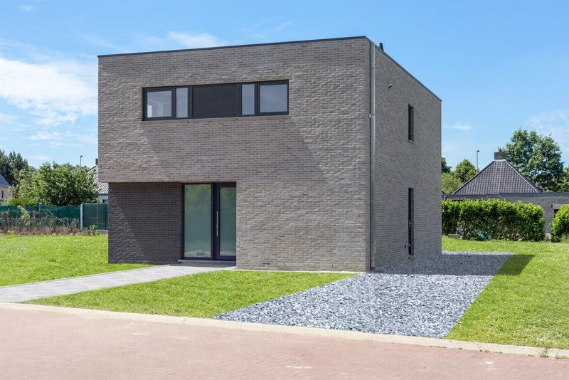 A compact brick house with a gravel path